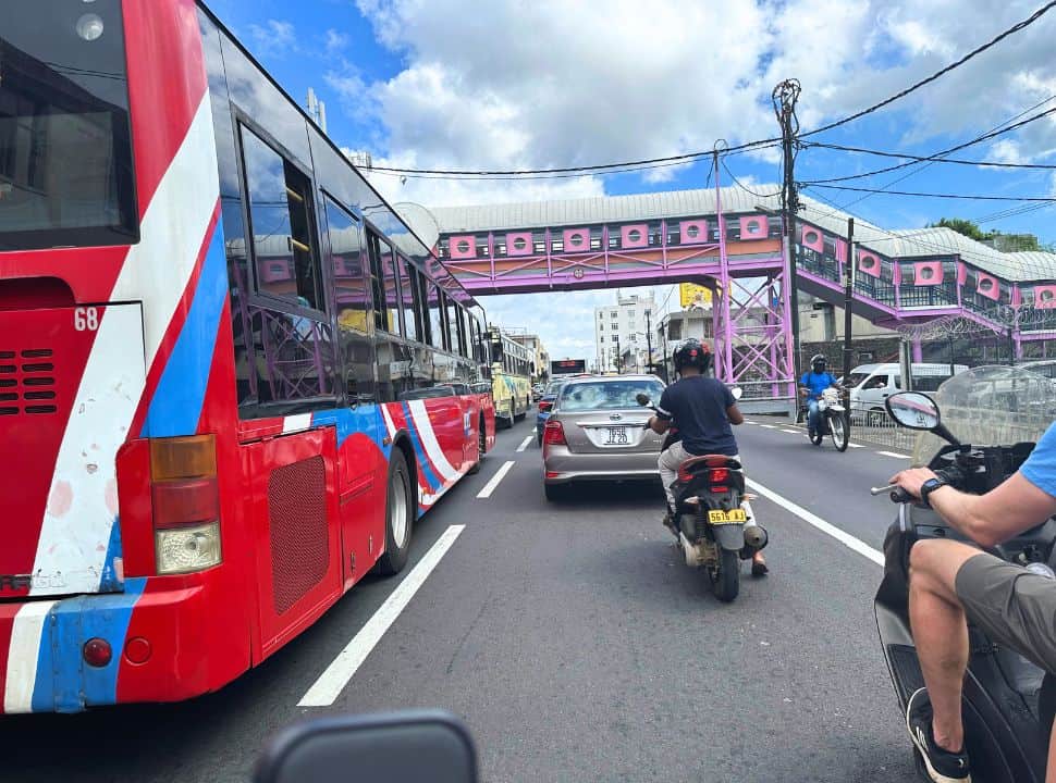 buses, cars and motor scooters on one of the main roads near Port Louis Mauritius