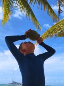 boy drinking coconut water straight from the coconut