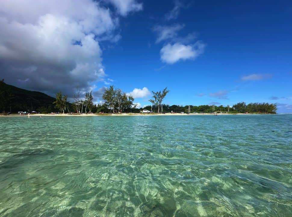 view of the beach from the water, island with cars visible in La Prairie beach Mauritius