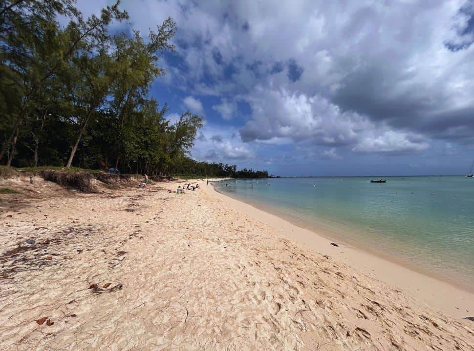 long stretched soft sanded beach with calm water in blue and turquoise, green trees along the edge at Mont Choisy Mauritius