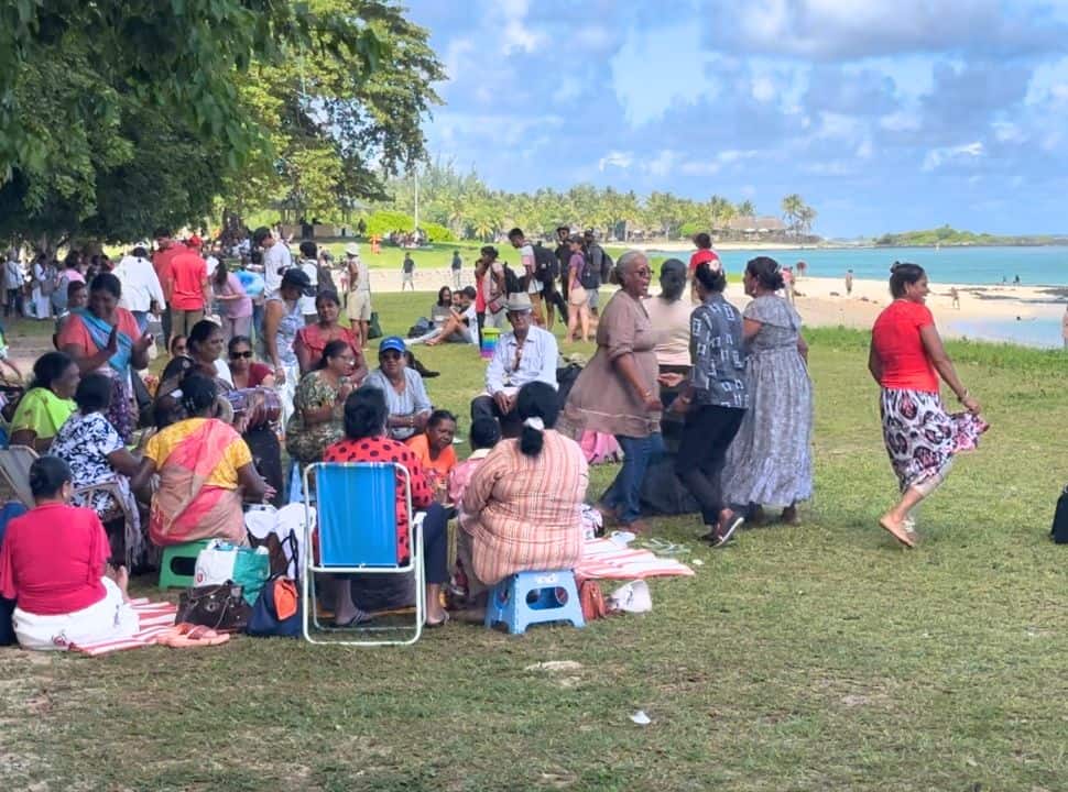 large group of women dancing and singing at the beach in Mauritius