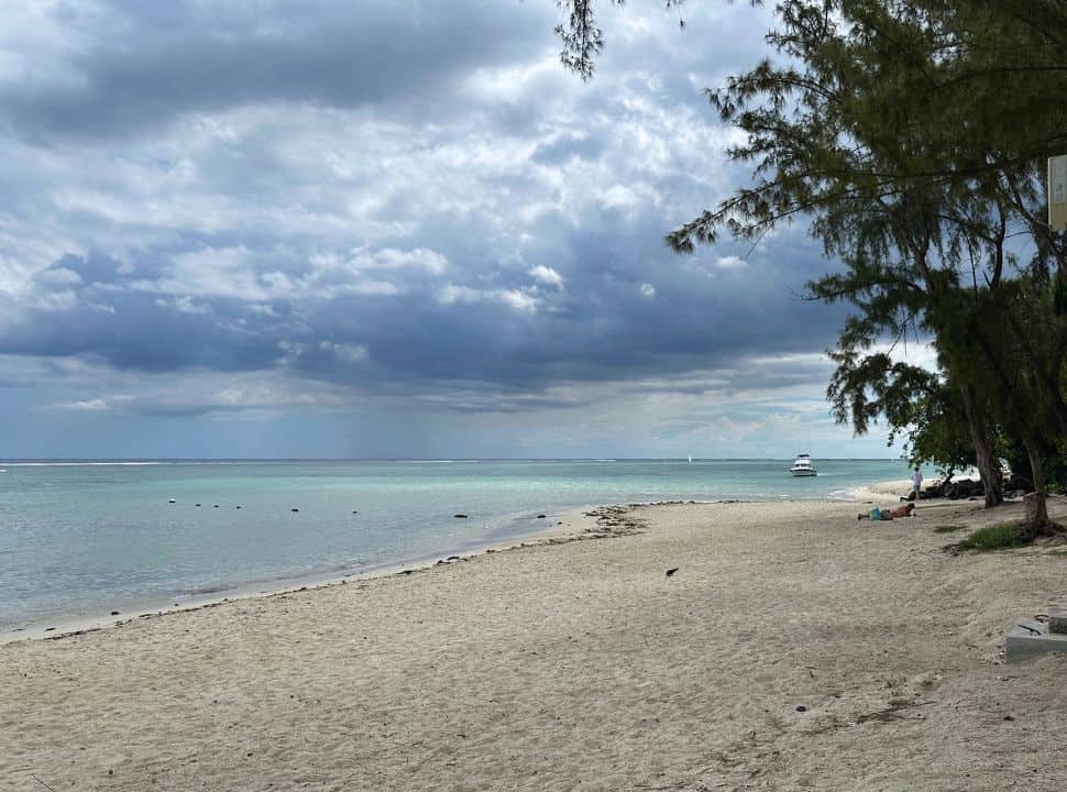 dark clouds looming above the white sanded Wolmar beach, the water still has the emerald turquoise color but less bright