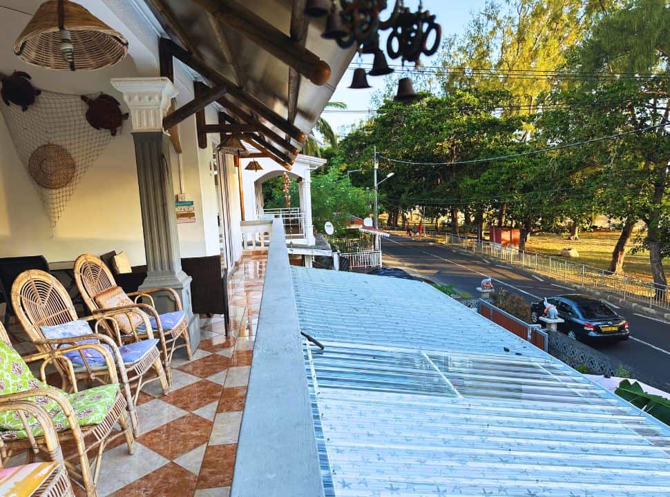 a balcony terrace on the first floor with view of the street and park with trees in Mauritius Le Morne Brabant