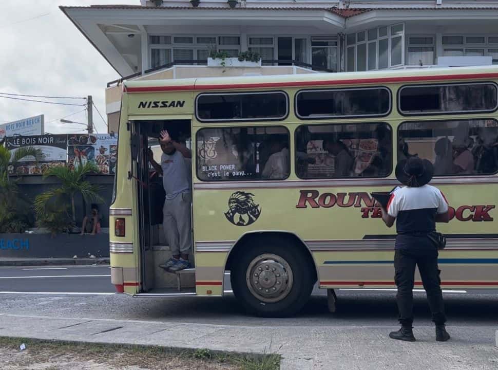 local bus leaving from the bus stop, a man is waving good bye in Flic en Flac