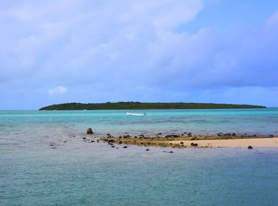 view of an island just offshore of Mauritius, there is boat passing by