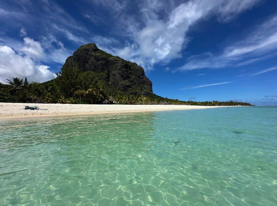 tropical beach, clear water with white sanded beach and palm trees with the le Morne mountain dominating in the back