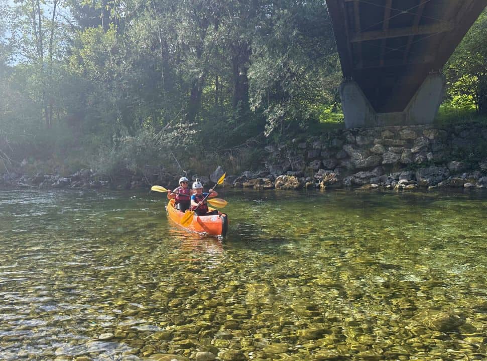 mother and son canoeing along the calm river at Bohinjska Bistrica, and ends at Camp Dania Slovenia