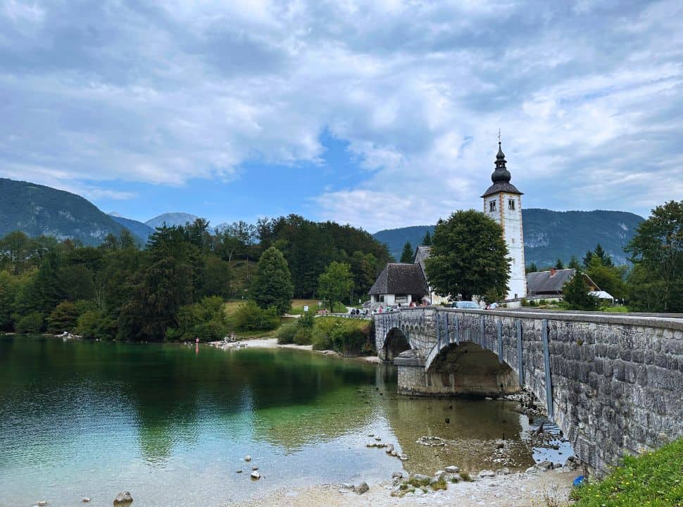 church set nearby an old bridge at the clear water lake Bohinj Slovenia