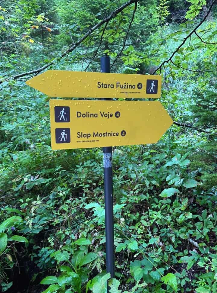 hiker sign pointing to Mostnica Waterfall and the village Stara Fuzina at Mostnica Gorge Slovenia