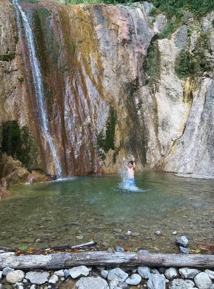 boy splashing in the waterfall pool at slap sapota slovenia