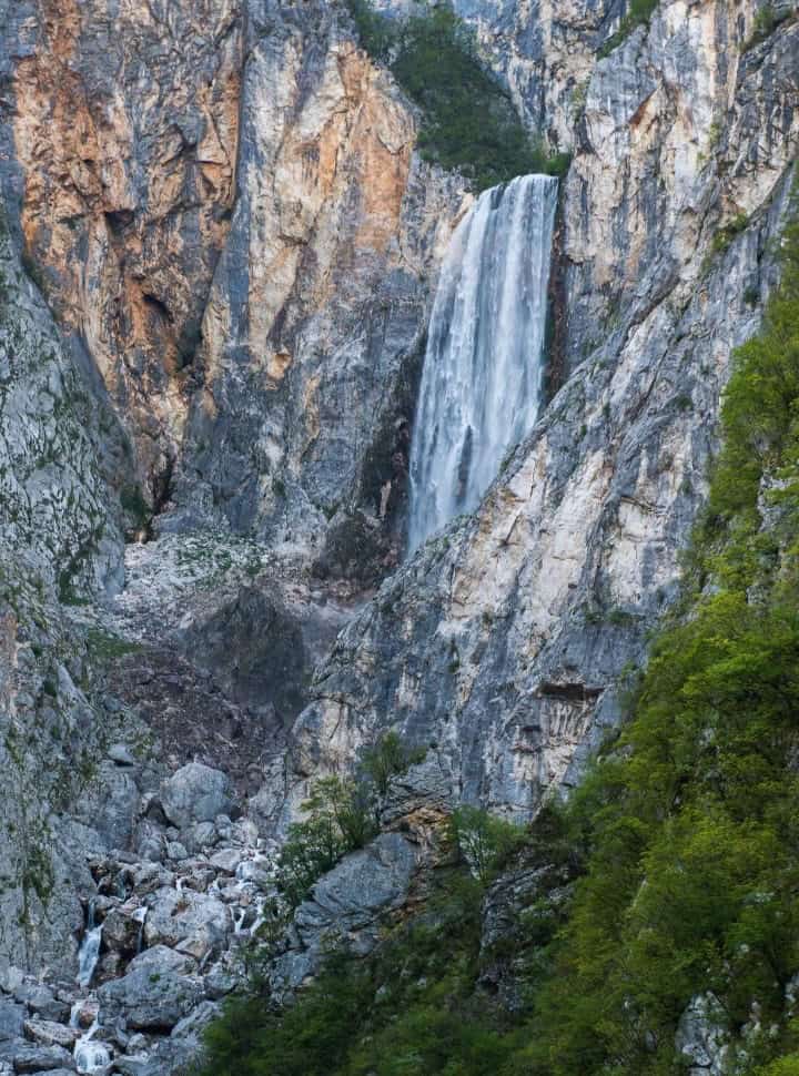 view of a waterfall set within a high cliff near Bovac Slovenia