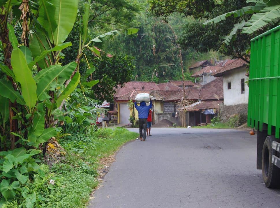 the main road to and around Sidemen Valley, its wider and there is a heavy truck passing while people are carrying a heavy load on their heads