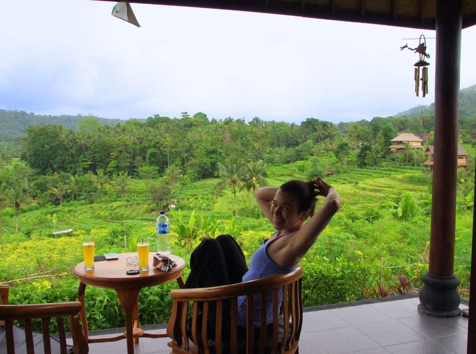 woman sitting on a terrace of her accommodation with stunning rice field valley view in Sidemen