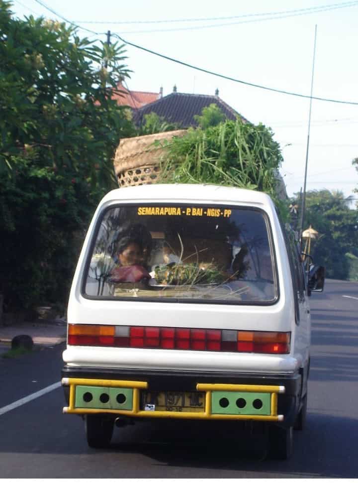 small mini van public transportation in Bali packed with people and good bought at the market