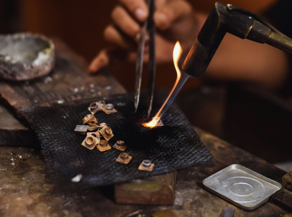 a jewelry maker melting silver