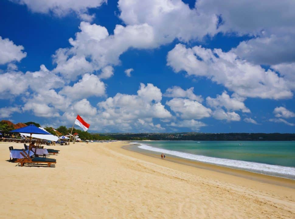 long stretched beach with soft sand, clear water and some sun bed on the Jimbaran Beach