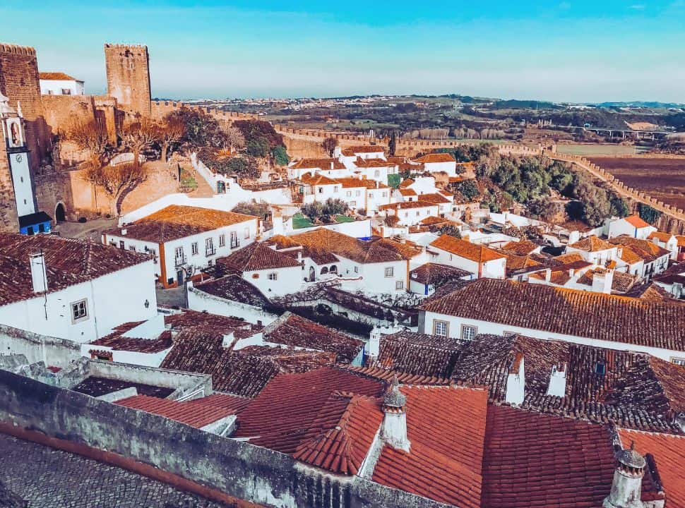 view of the walled medievel town Obidos Portugal with watch towers and charming while houses