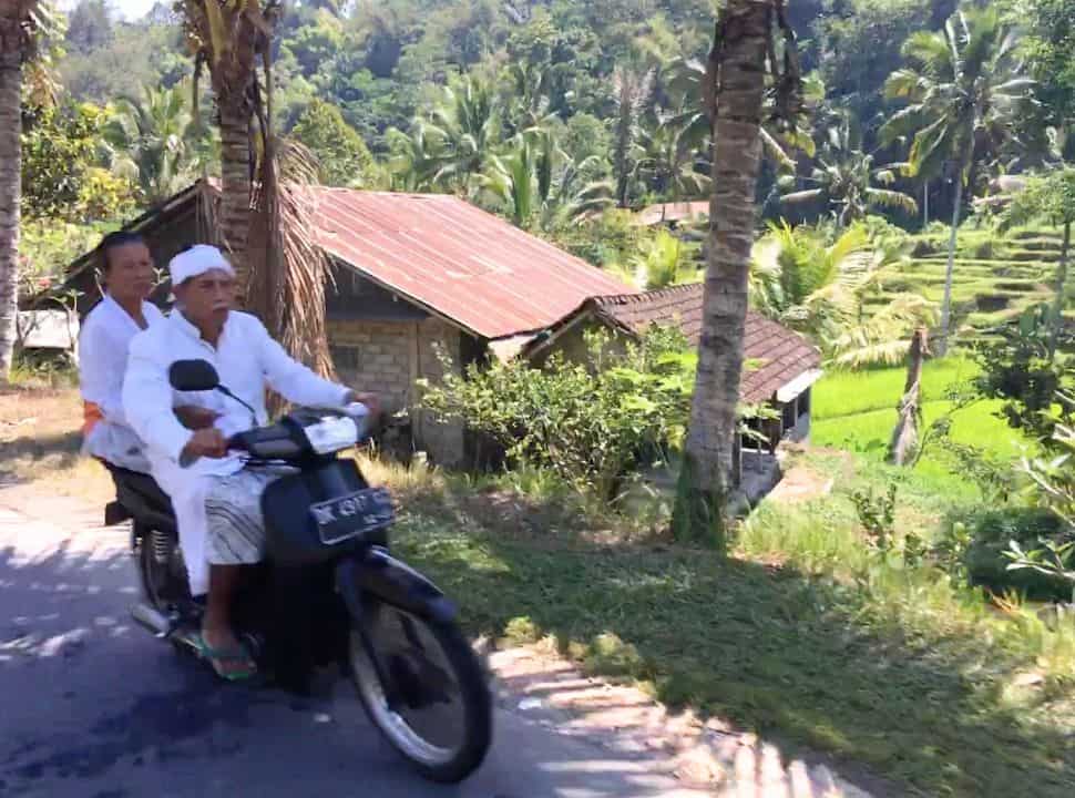 Balinese man and woman on a motor scooter in Wongayagede Batukaru Bali