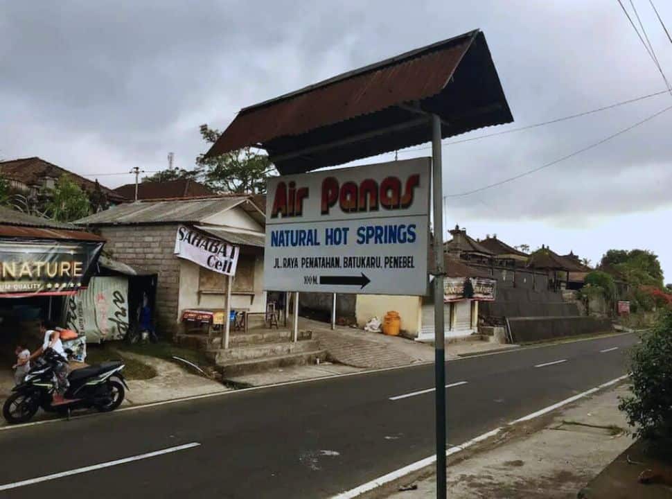 sign along the road indicating the natural hot springs 'air panas' in Penatahan village, Bali