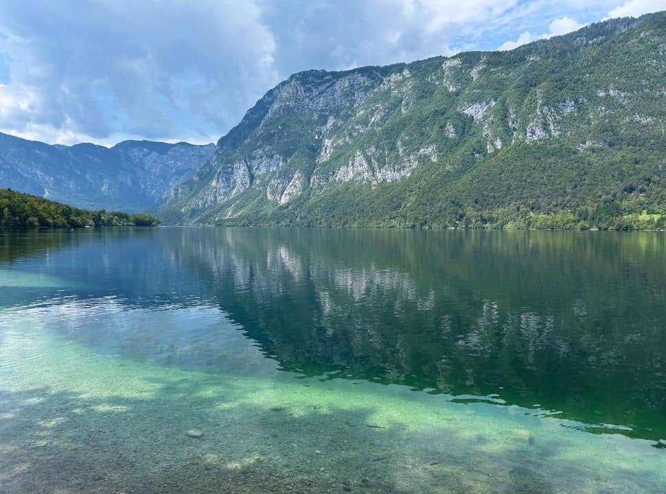incredible clear water of lake bohinj Slovenia which is surrounded by mountain slopes 