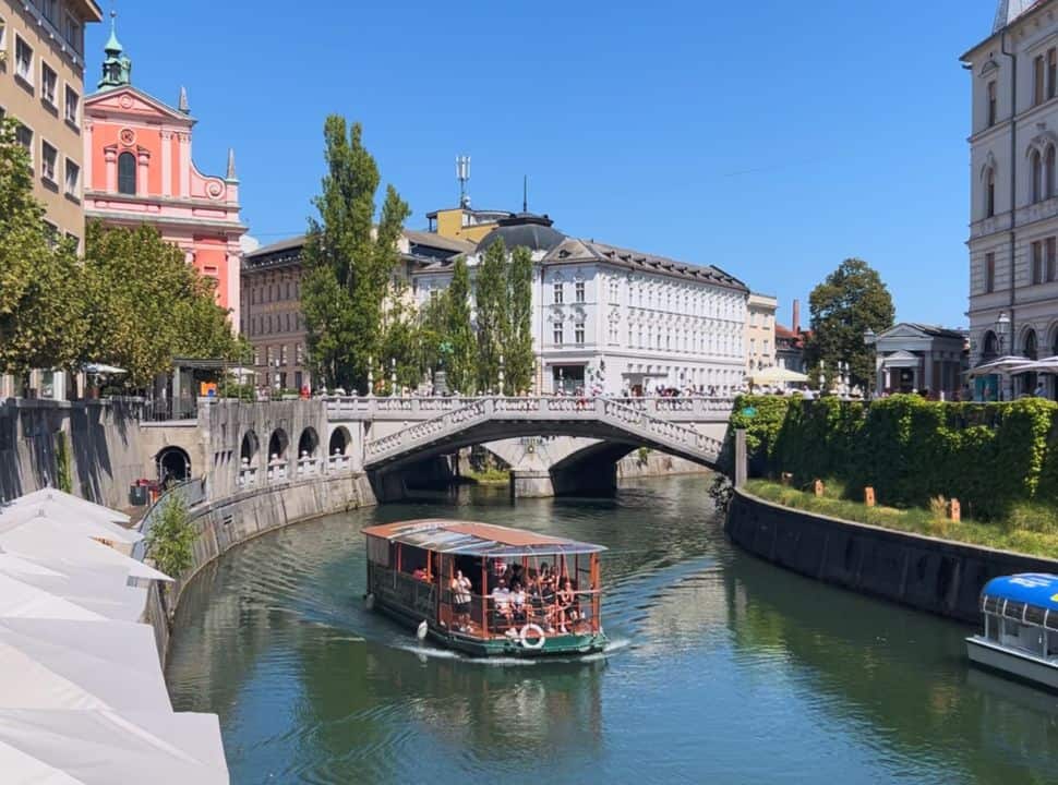 river cruise boat passing the famous bridge in Ljubliana Slovenia