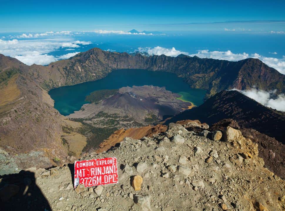crater with dark blue water surrounded by clouds on Lombok island