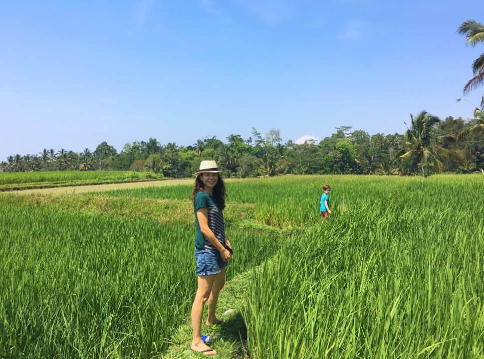 mother and son walking through green lush rice fields in Bali
