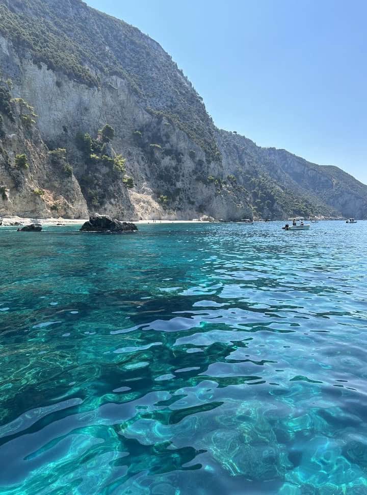rent a boat in Corfu Without License, small boats navigating along the shore of stunning beaches