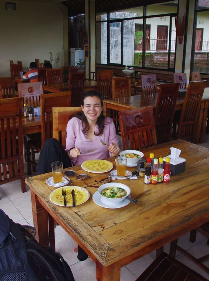 woman enjoying a Balinese pancake and vegetable soup in a quiet restaurant on the way to north Bali