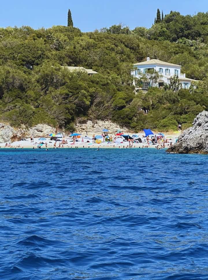 small crowded beach seen from the rental boat in Corfu without license