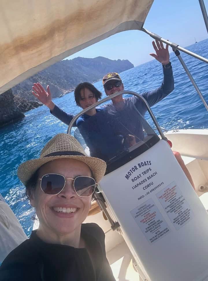 family of three posing for a selfie on a boat rented without licence in Corfu Greece.