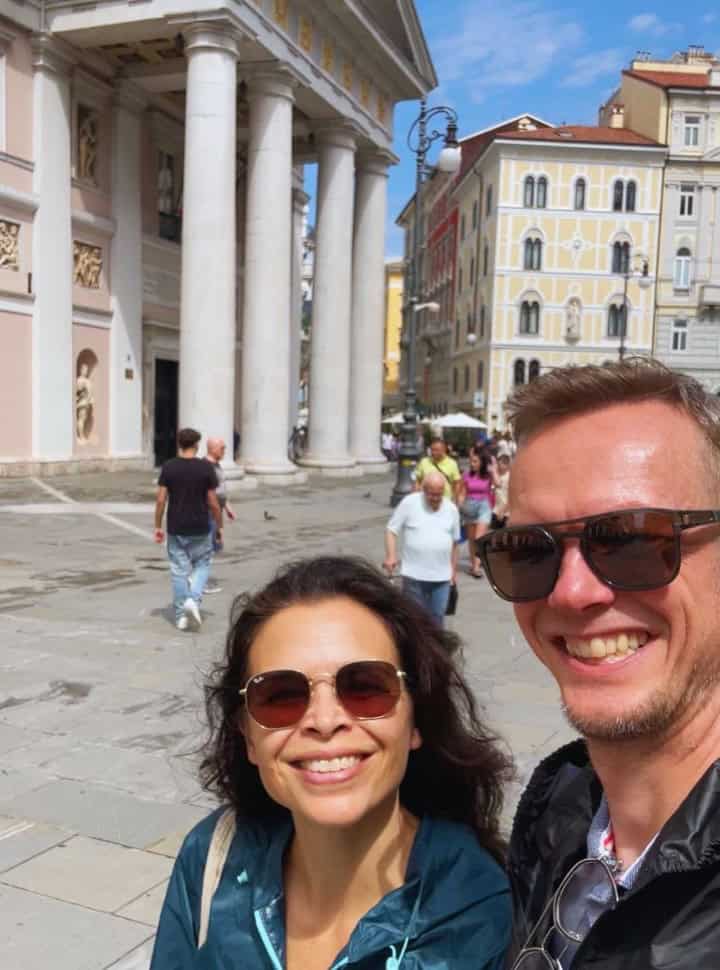 Couple posing for a selfie at a historic square with impressive buildings in trieste Slovenia