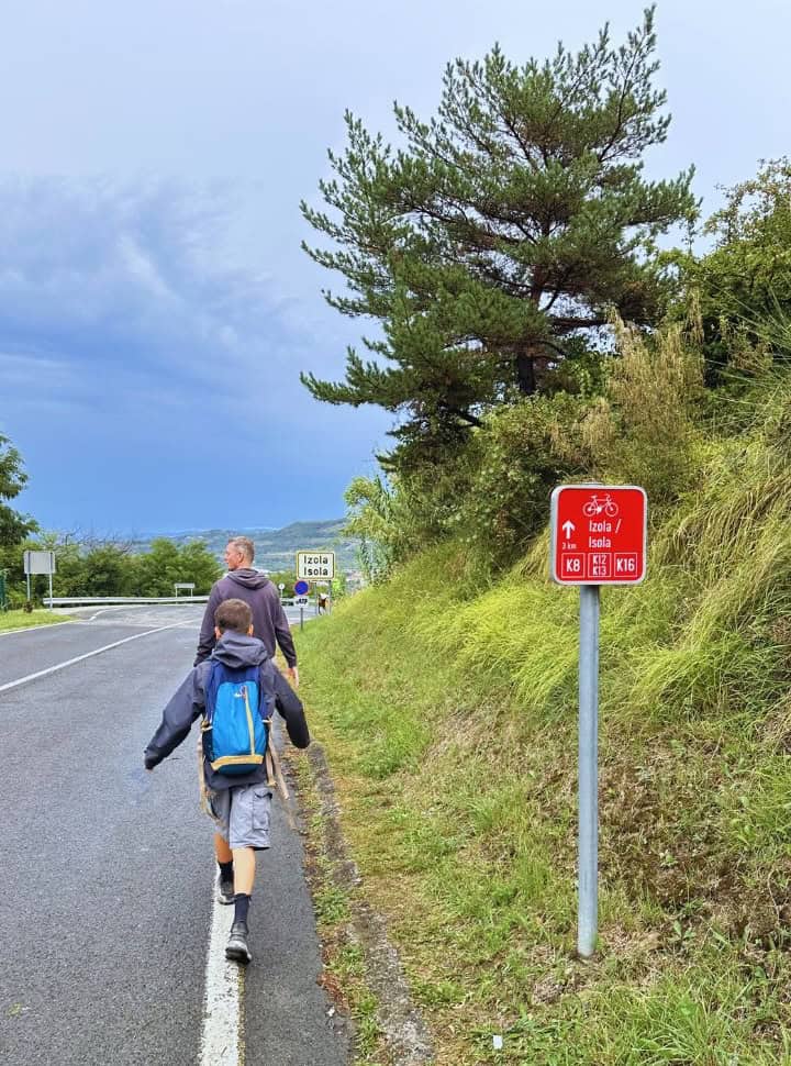 father and son walking along the main road towards Izola town Slovenia