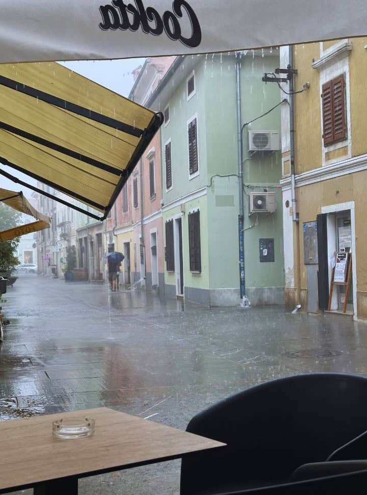 downpour in small street with colorful buildings in Izola Slovenia