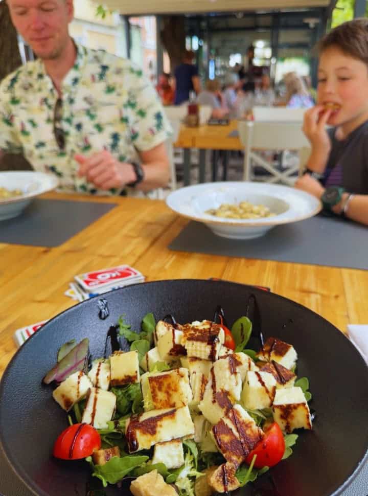 father and sun sitting at the table while the dish on the picture is a salad with cheese in a restaurant in Izola Slovenia
