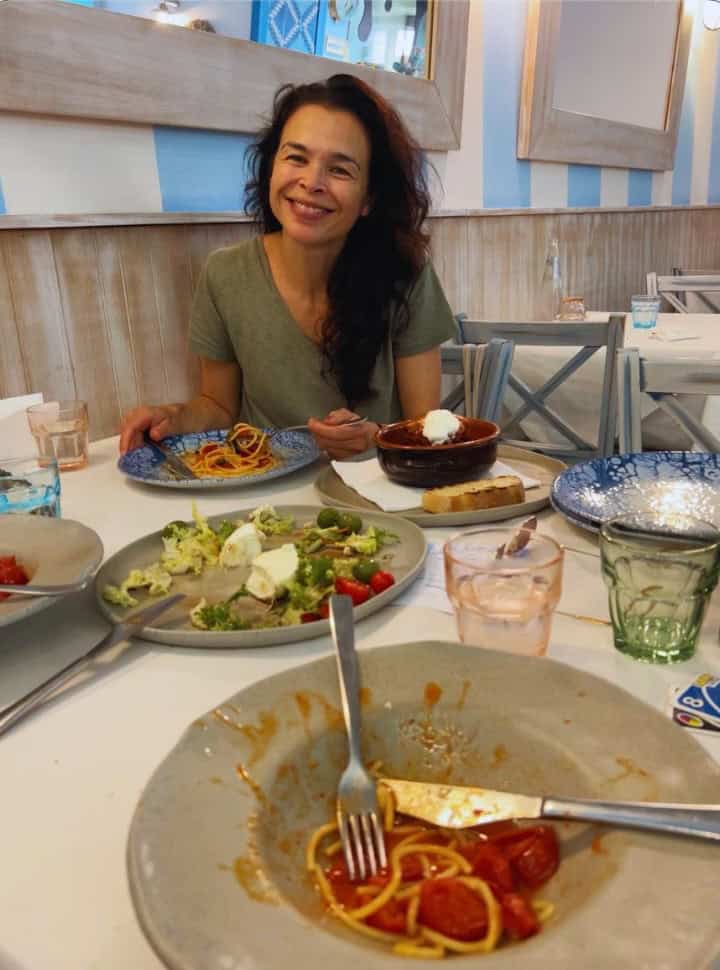 woman having pasta and salad at an Italian restaurant in Trieste Slovenia