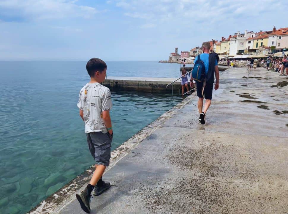 father and son walking along the swimming spot in Piran Slovenia