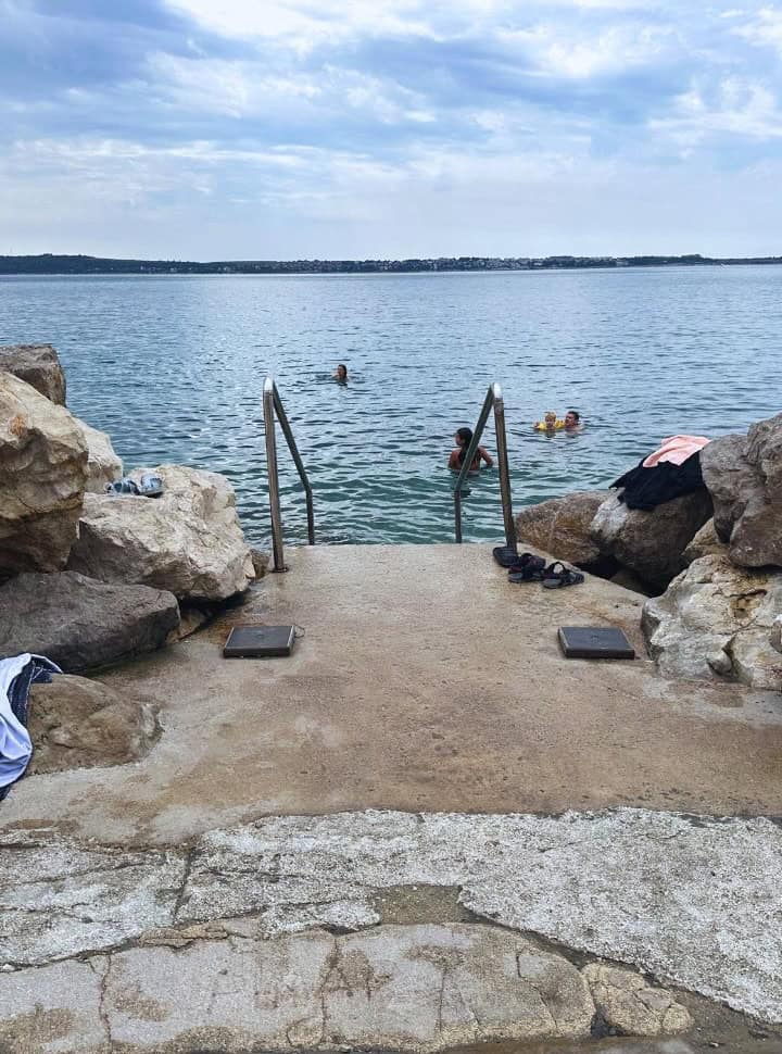 clear cement between the boulders with a ladder for people to easily enter the ocean at Piran Slovenia