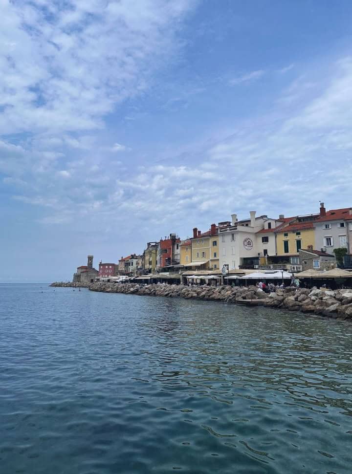 the famous coast line of Piran with restaurants, where people can enter the water between the boulders