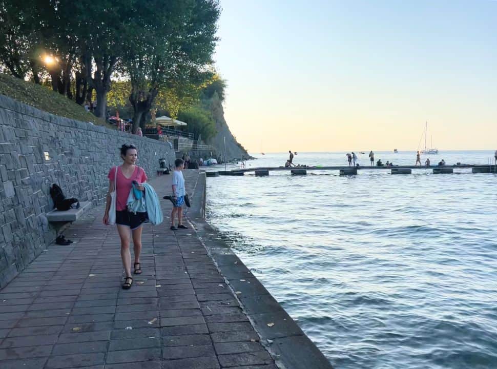 mother and son walking along the cement promenade at the coast of Slovenia