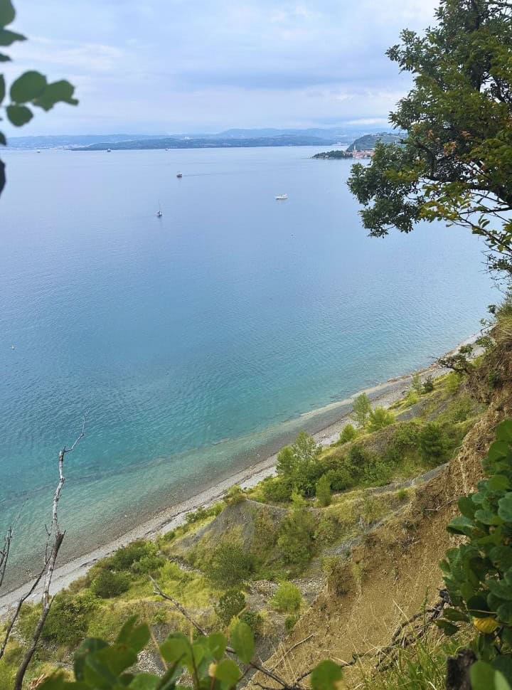view from a cliff on a deserted beach with turquoise clear water Slovenia coast