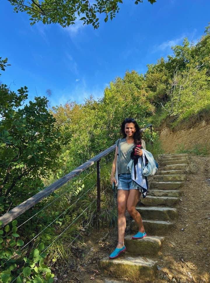 woman walking down the stairs between nature towards the beach nearby Izola Slovenia