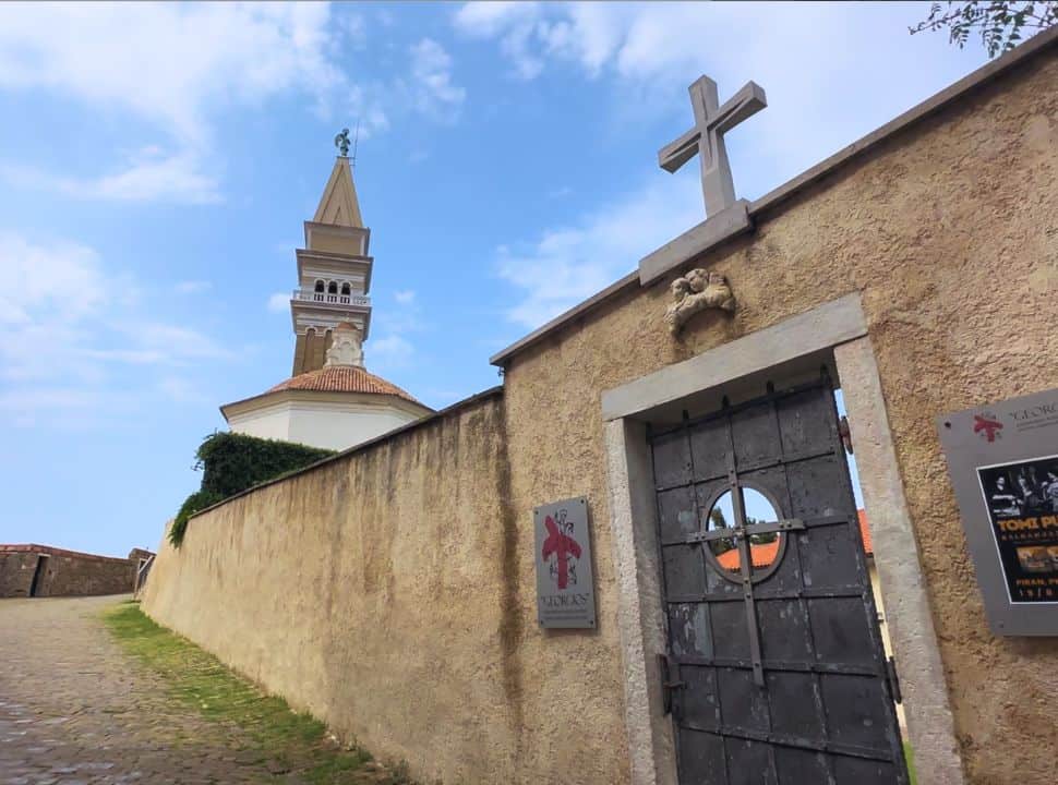 cobbled stone path along a stone wall from the church grounds, leading up to the bell tower of Piran Slovenia