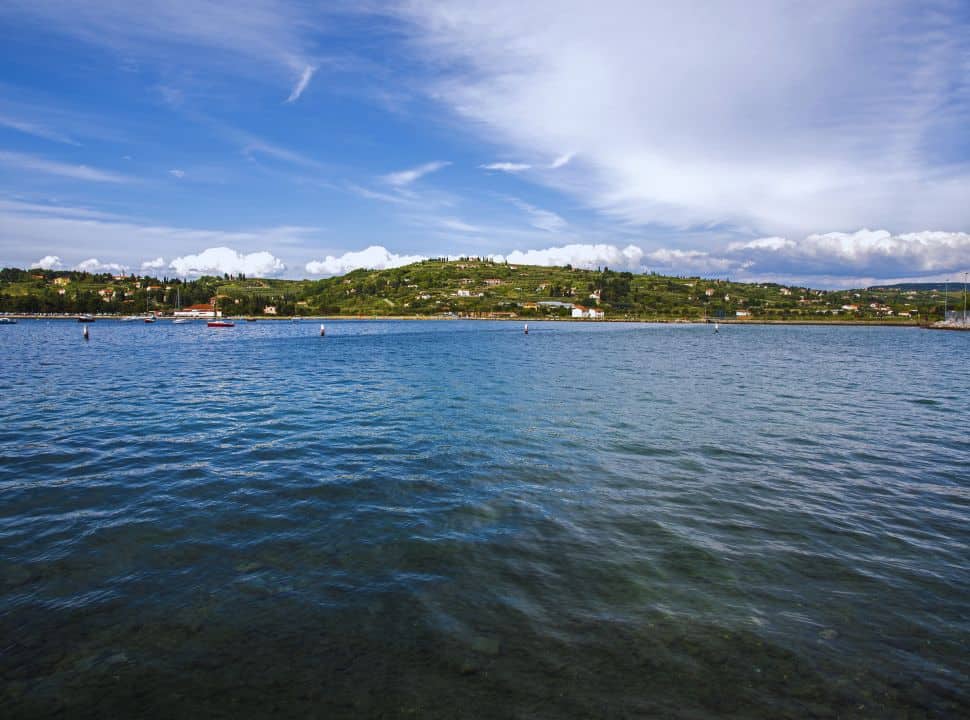 ocean front with in the distance houses and green hills in Strunjan Slovenia